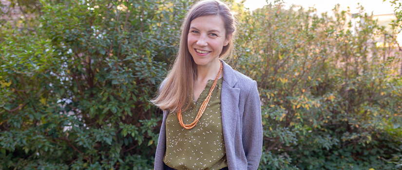 Woman smiling with flower shirt on on outside