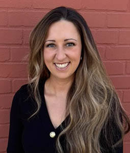 Shea Ferguson standing in front of a brick wall.