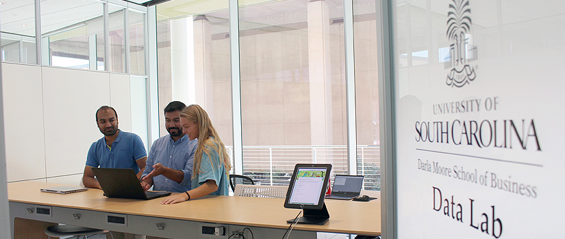 Three students working in the Moore School's Data Lab.