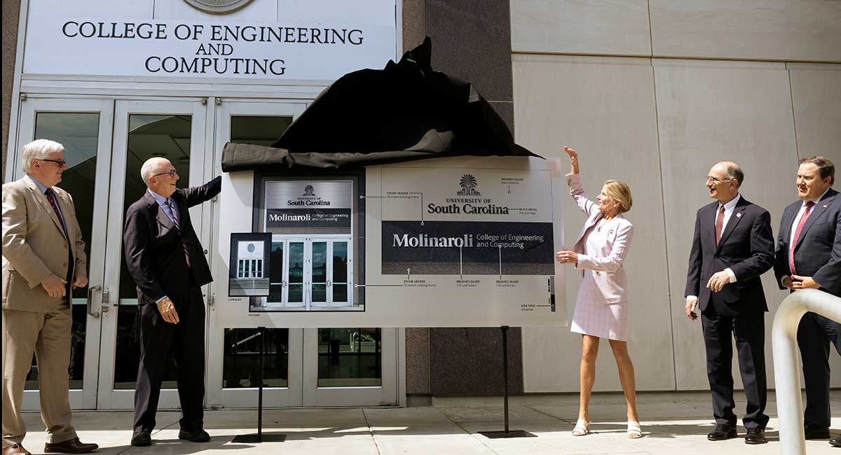 USC President Michael Amaridis, Alex and Kristin Molinaroli, Dean Hossein Haj-Hariri and USC Board Chair Westbrook watch as the college's name is unveiled.
